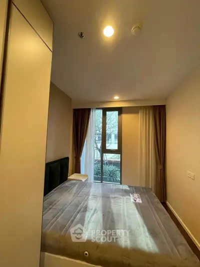 Cozy bedroom with large window and modern decor in a stylish apartment.