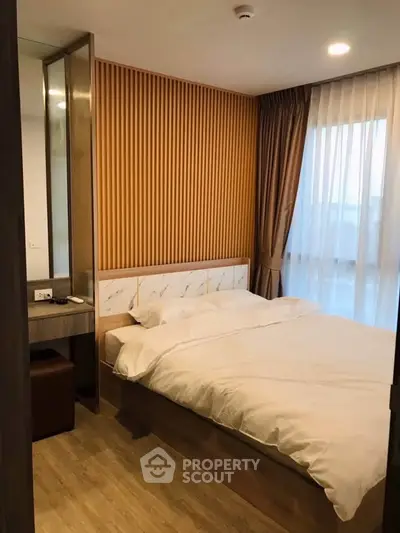 Cozy bedroom with modern decor and large window for natural light