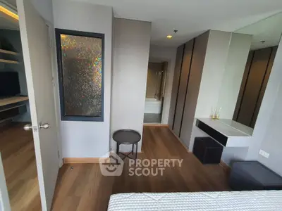 Modern bedroom with wooden flooring and stylish decor in a contemporary apartment.