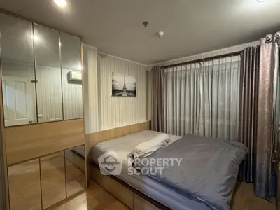 Cozy bedroom with mirrored wardrobe and elegant curtains in modern apartment