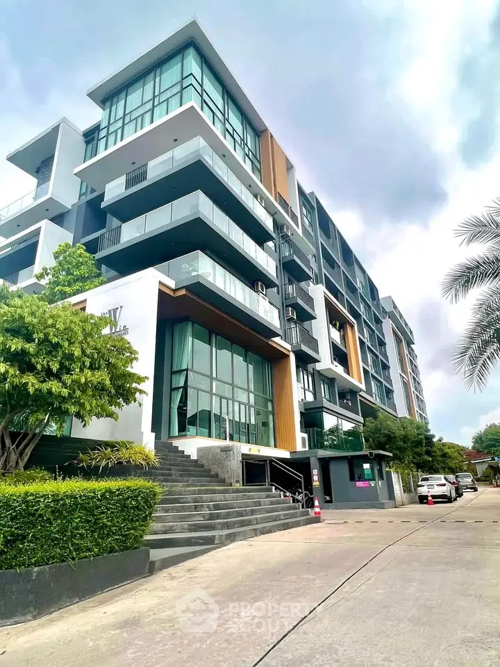 Modern multi-story apartment building with sleek design and large windows