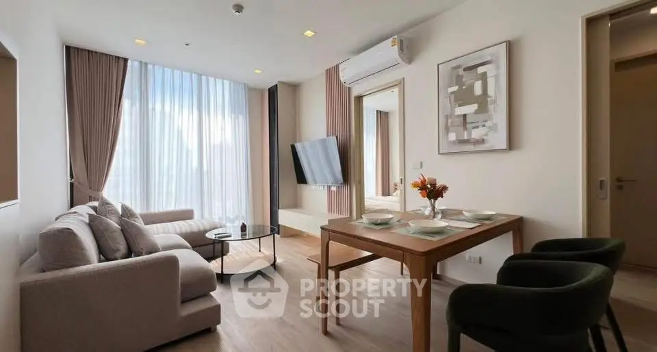 Modern living room with stylish furniture and large window offering natural light.