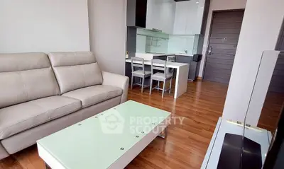 Modern living room with sleek kitchen and stylish furniture in open layout apartment.