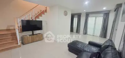 Spacious living room with modern decor and sleek staircase in a contemporary home.