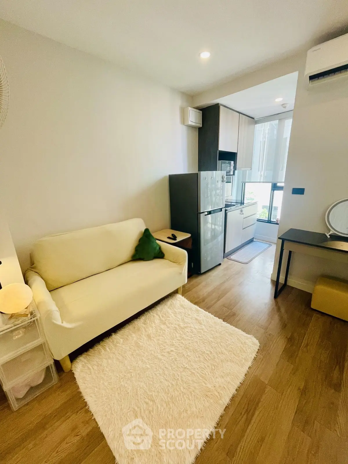 Cozy living room with modern kitchen and natural light, perfect for urban living.