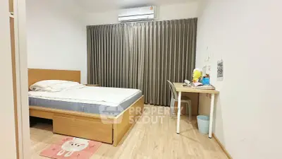 Cozy bedroom with wooden flooring, modern bed, and study desk, perfect for relaxation and productivity.