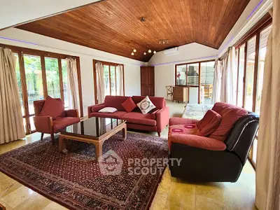 Spacious living room with wooden ceiling and large windows in a cozy home