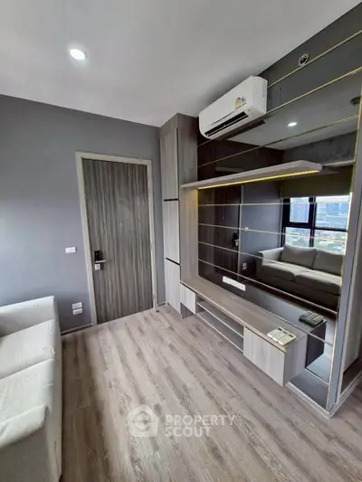 Modern living room with sleek design, featuring air conditioning and stylish wood flooring.