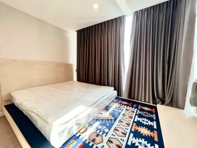 Spacious bedroom with large window and stylish decor in modern apartment
