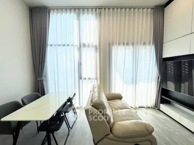 Modern living room with elegant sofa and dining area, featuring floor-to-ceiling windows and stylish curtains.