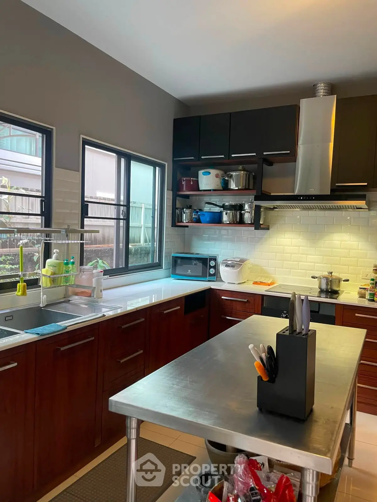 Modern kitchen with sleek cabinetry, stainless steel island, and large windows for natural light.