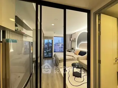 Modern studio apartment with stylish decor and city view balcony.