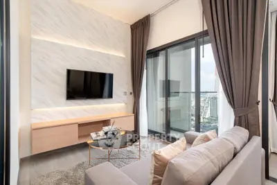 Modern living room with city view, elegant decor, and cozy seating area.