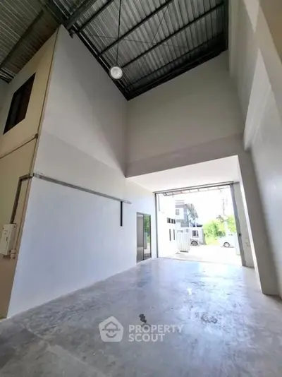 Spacious industrial warehouse with high ceilings and large entryway