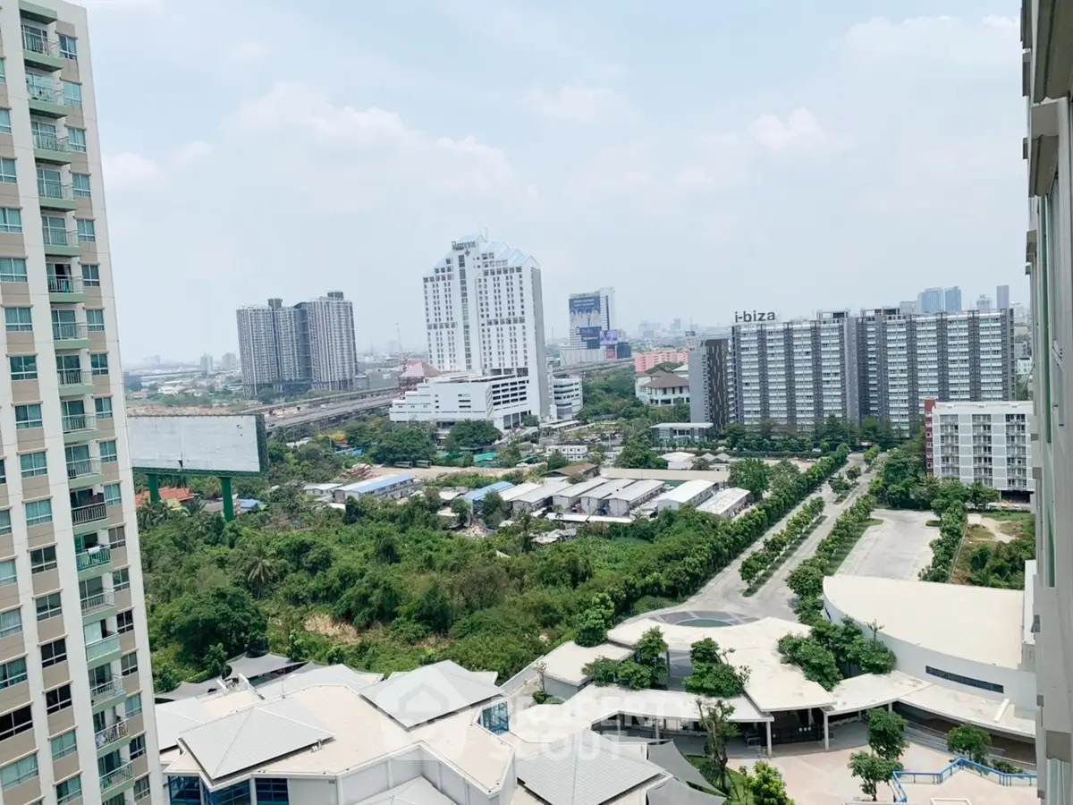 Stunning cityscape view from high-rise balcony overlooking urban skyline and greenery.