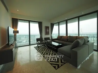 Spacious living room with panoramic city view and modern furnishings.