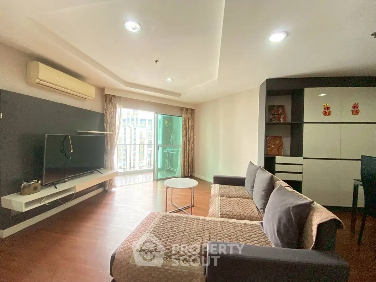 Spacious living room with modern decor and balcony access