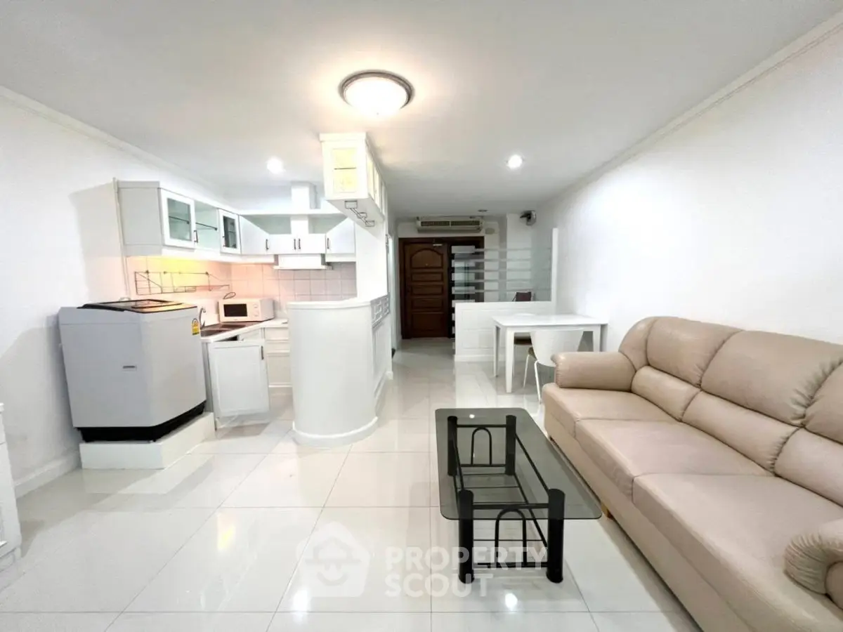 Spacious open-plan living room with modern kitchen and elegant furnishings.