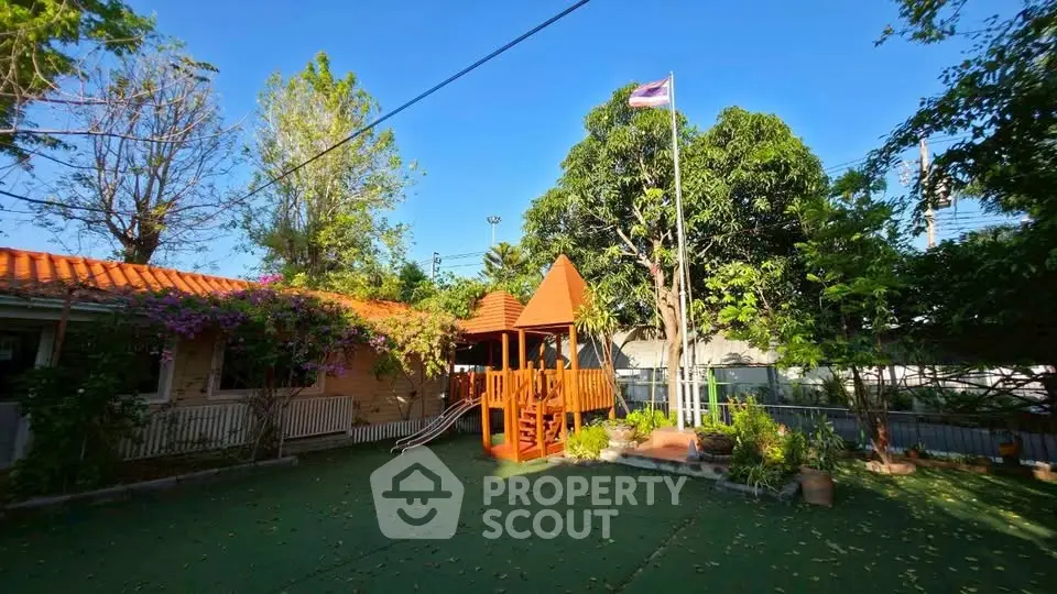 Charming backyard with playhouse and lush greenery, perfect for family gatherings and outdoor fun.