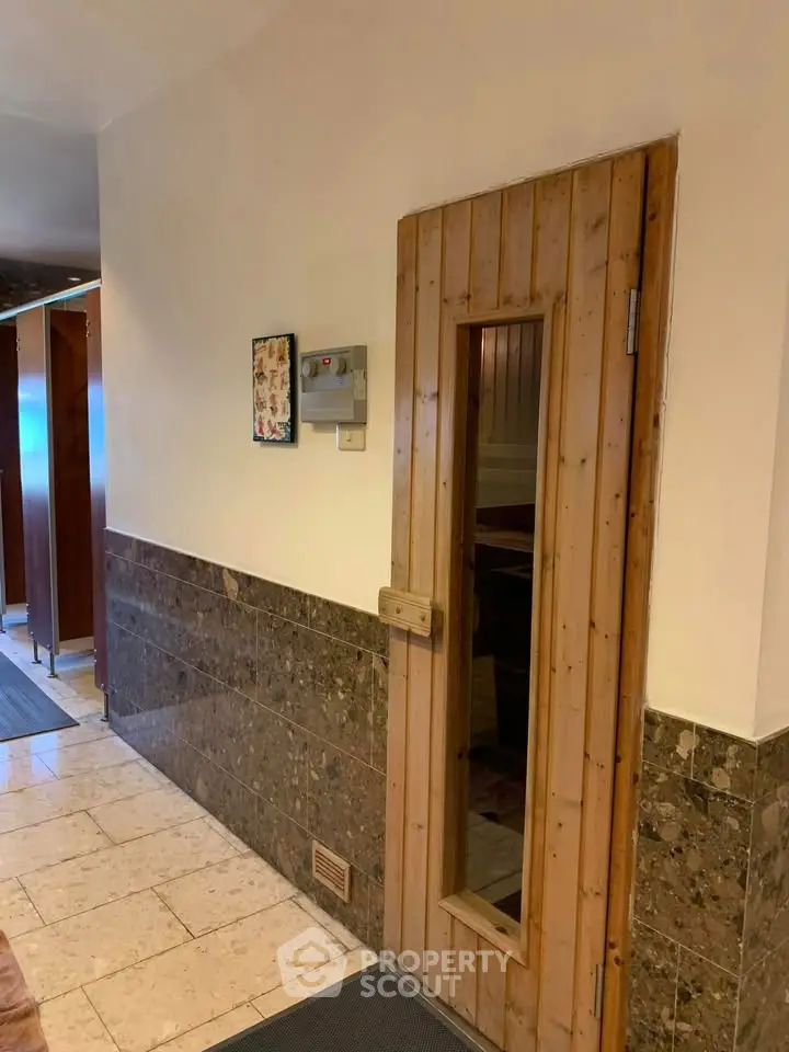 Charming sauna entrance in a luxurious building with elegant marble walls.