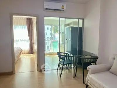 Modern apartment interior with glass partition, cozy living area, and bright bedroom view.