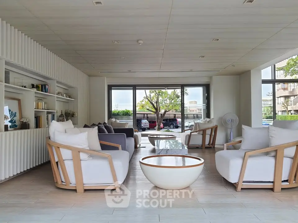Spacious modern living room with elegant furniture and large windows offering natural light.