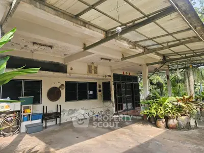 Charming rustic home exterior with spacious covered patio and lush greenery.