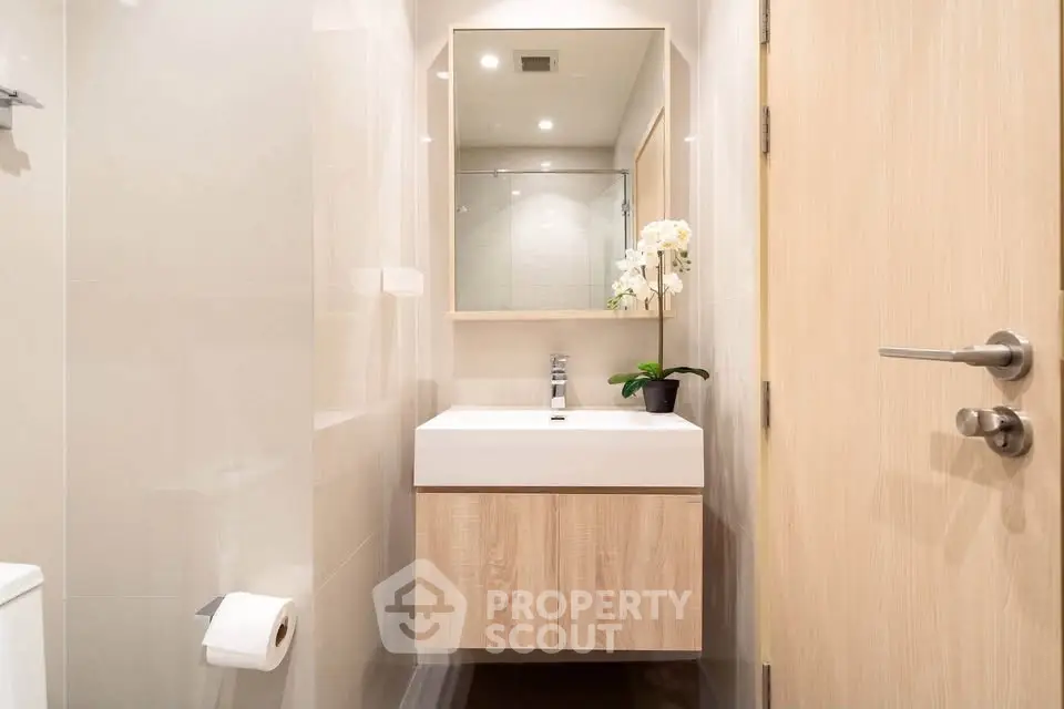 Modern bathroom with sleek vanity and elegant mirror in a contemporary apartment.