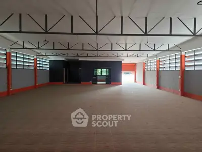 Spacious industrial warehouse with high ceilings and ample natural light.