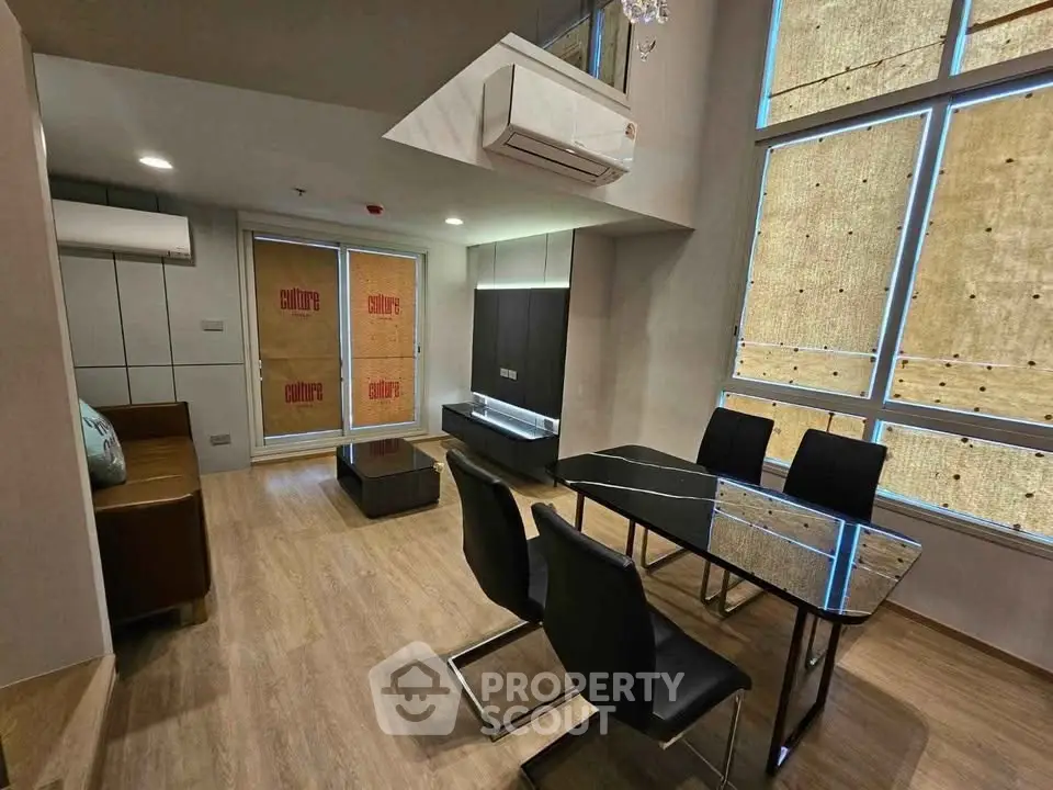 Modern living room with sleek dining area and large windows, featuring contemporary furniture and stylish decor.