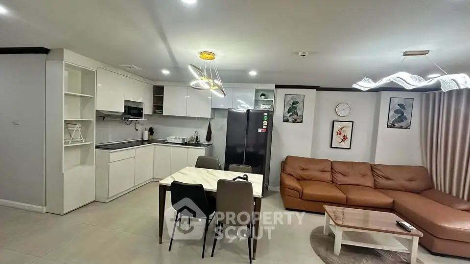Modern open-plan living room and kitchen with stylish lighting and cozy seating area.
