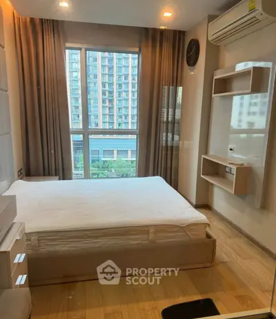 Modern bedroom with large window and city view in high-rise apartment