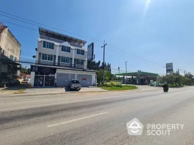 Commercial building with adjacent gas station on a sunny day