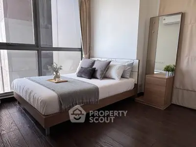 Modern bedroom with large window, stylish decor, and elegant wooden flooring.