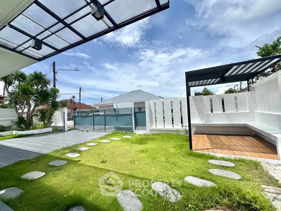 Spacious modern backyard with lush green lawn and stylish pergola, perfect for outdoor relaxation.