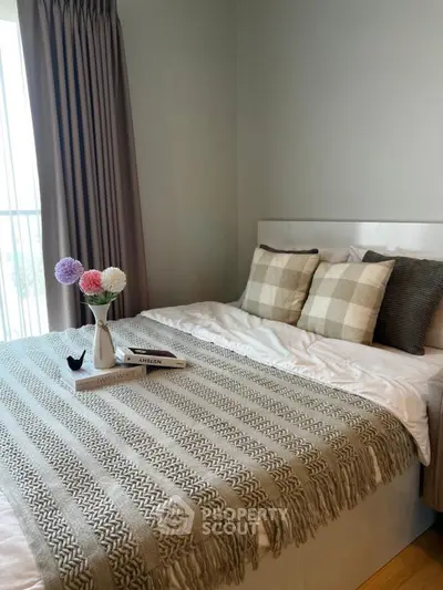 Cozy bedroom with stylish decor and natural light, perfect for relaxation and comfort.