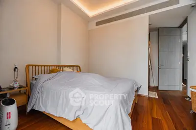 Spacious bedroom with wooden flooring and modern decor, perfect for a cozy retreat.