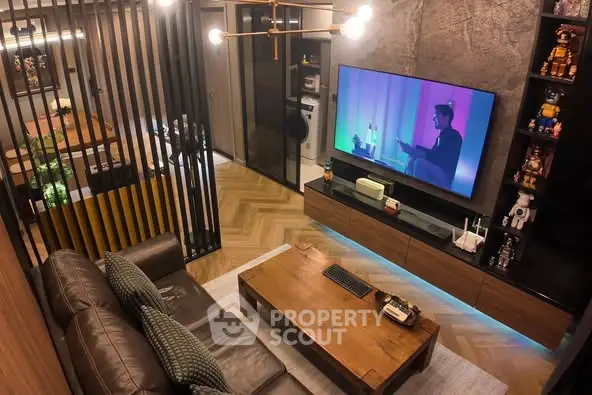 Stylish modern living room with leather sofa and large TV, featuring elegant decor and warm lighting.