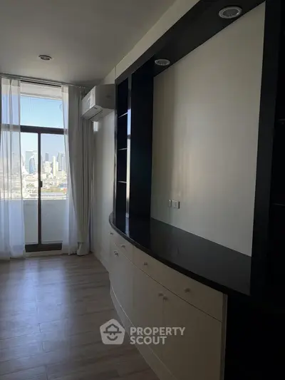 Spacious room with built-in shelving and city view, perfect for modern living.