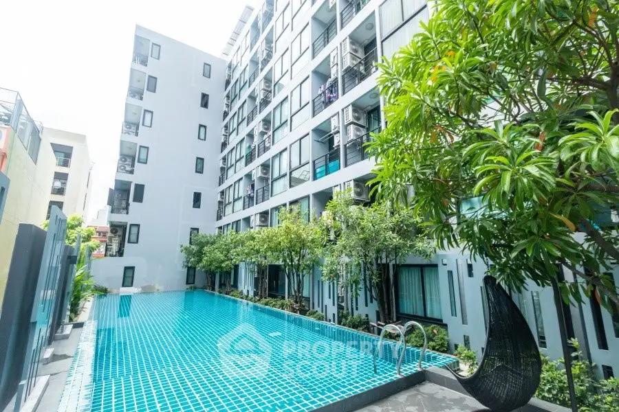 Modern apartment building with a luxurious pool and lush greenery