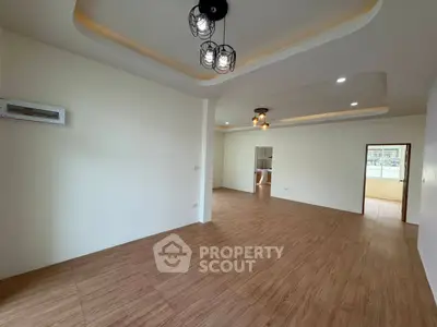 Spacious modern living room with stylish ceiling lights and wooden flooring