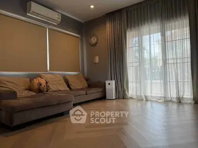 Spacious living room with cozy sofa and large windows for natural light.