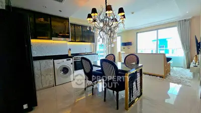 Luxurious open-plan kitchen and living area with elegant chandelier and modern appliances.