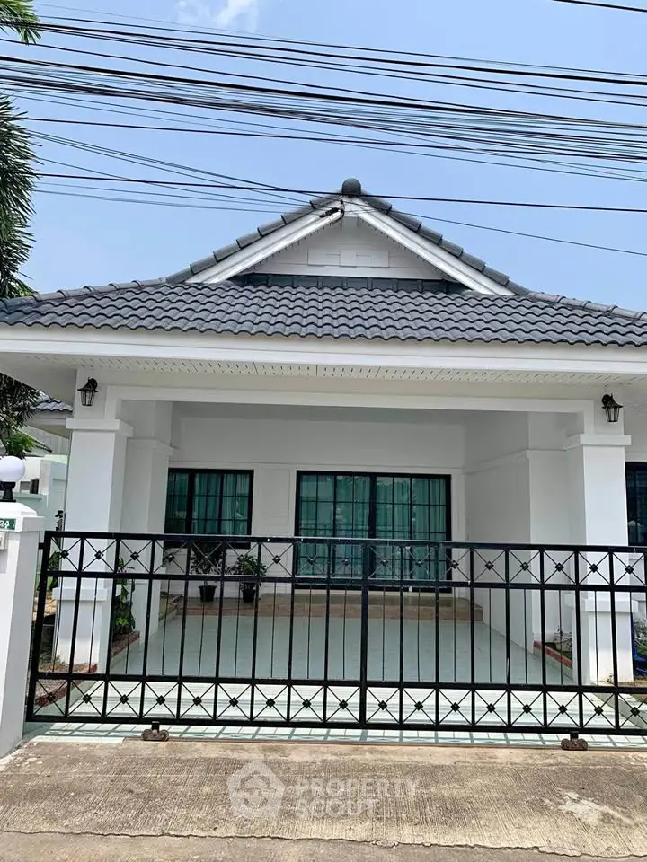 Charming single-story house with modern roof and gated entrance, perfect for family living.