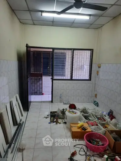 Spacious storage room with tiled flooring and ample natural light.