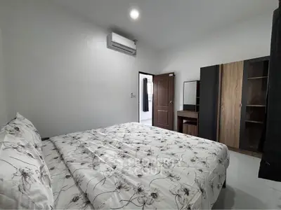 Spacious bedroom with modern furnishings and air conditioning, perfect for comfort and relaxation.