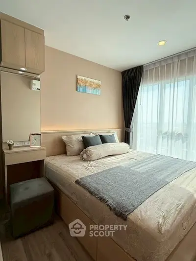 Cozy bedroom with modern decor and large window offering natural light