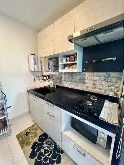 Modern kitchen with sleek cabinetry and gas stove, featuring efficient storage solutions.