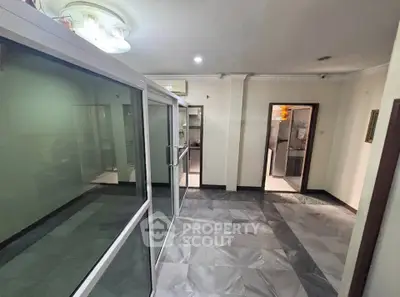 Spacious interior with glass partitions and modern flooring in a versatile living space.