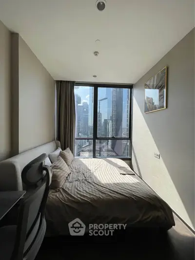 Modern bedroom with city view, featuring large windows and stylish decor.